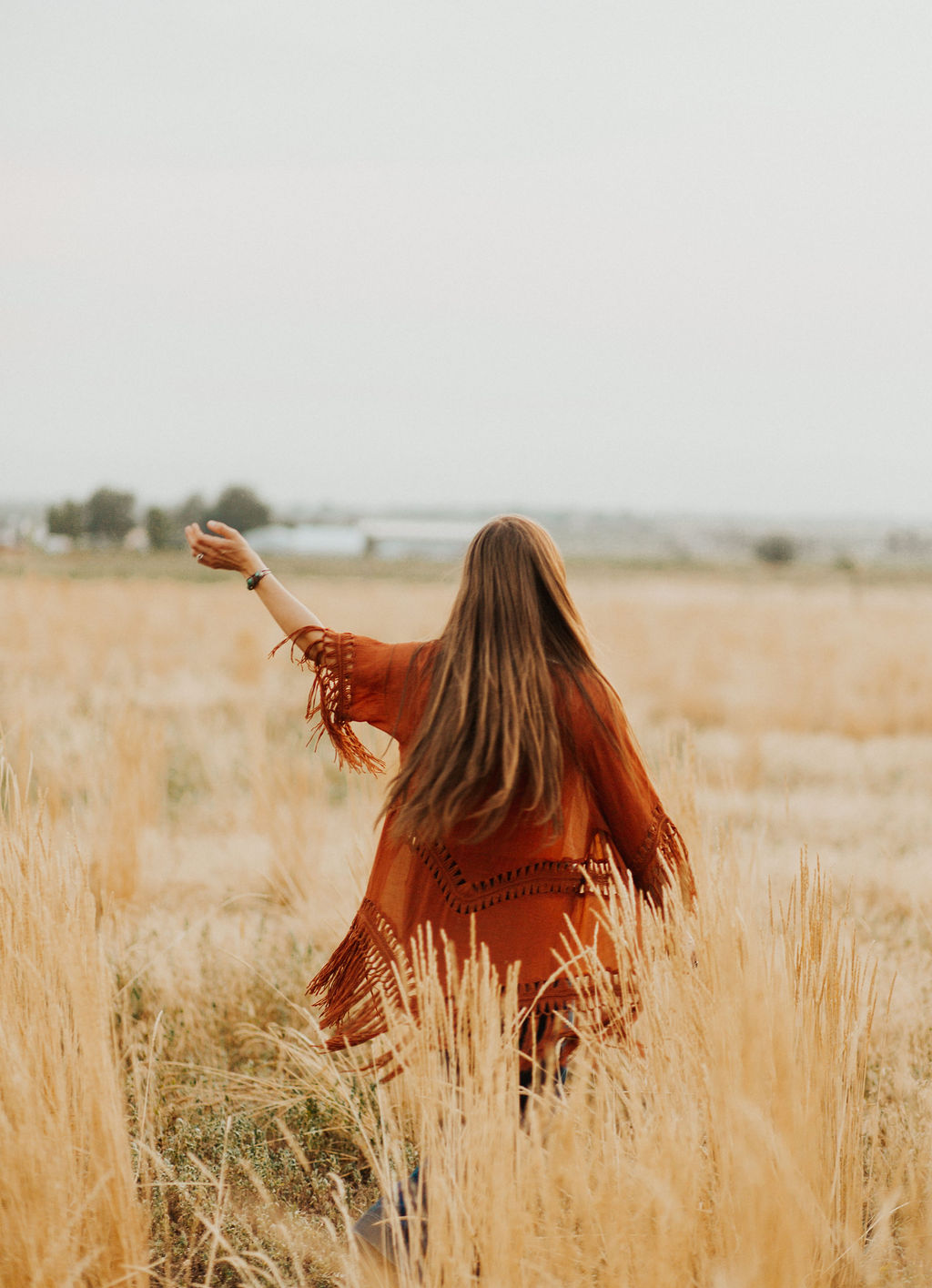 woman with waist length dark blonde hair dancing in a field because she's so happy to teach Christian business owners how to get a vision for their business
