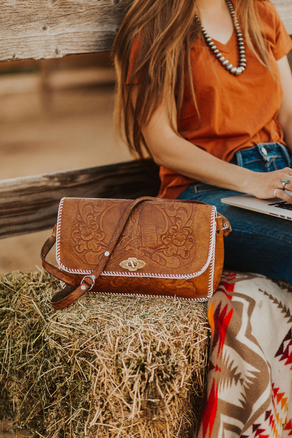 western vintage leather purse sitting on a haybale by a woman Christian business coach teaching lead generation strategies